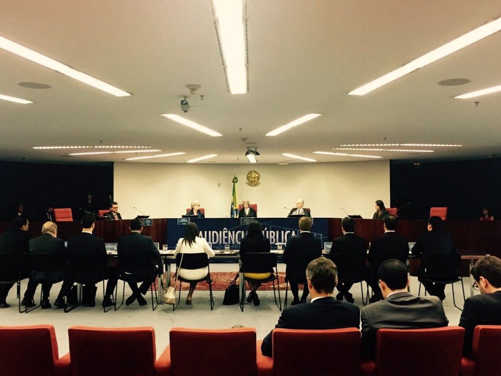 Photo of the public hearing at the Brazilian Federal Supreme Court to discuss WhatsApp blocks, composed of the ministers of the Federal Supreme Court sitting at the director's table in front of the public, also seated.