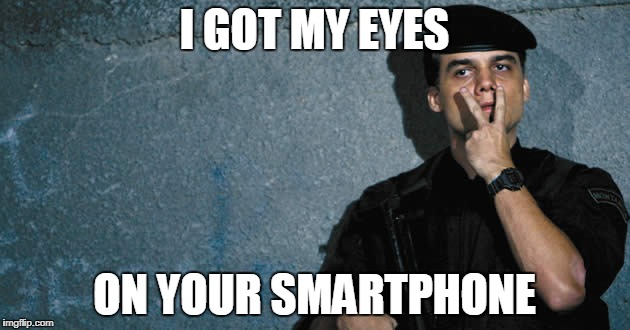 Photo of the character Capitão Nascimento, played by Wagner Moura in the movie Tropa de Elite, wearing a police uniform with his hand close to his face, pointing his index and middle fingers to his eyes, with the text "I got my eyes on your smartphone" at the bottom of the image.