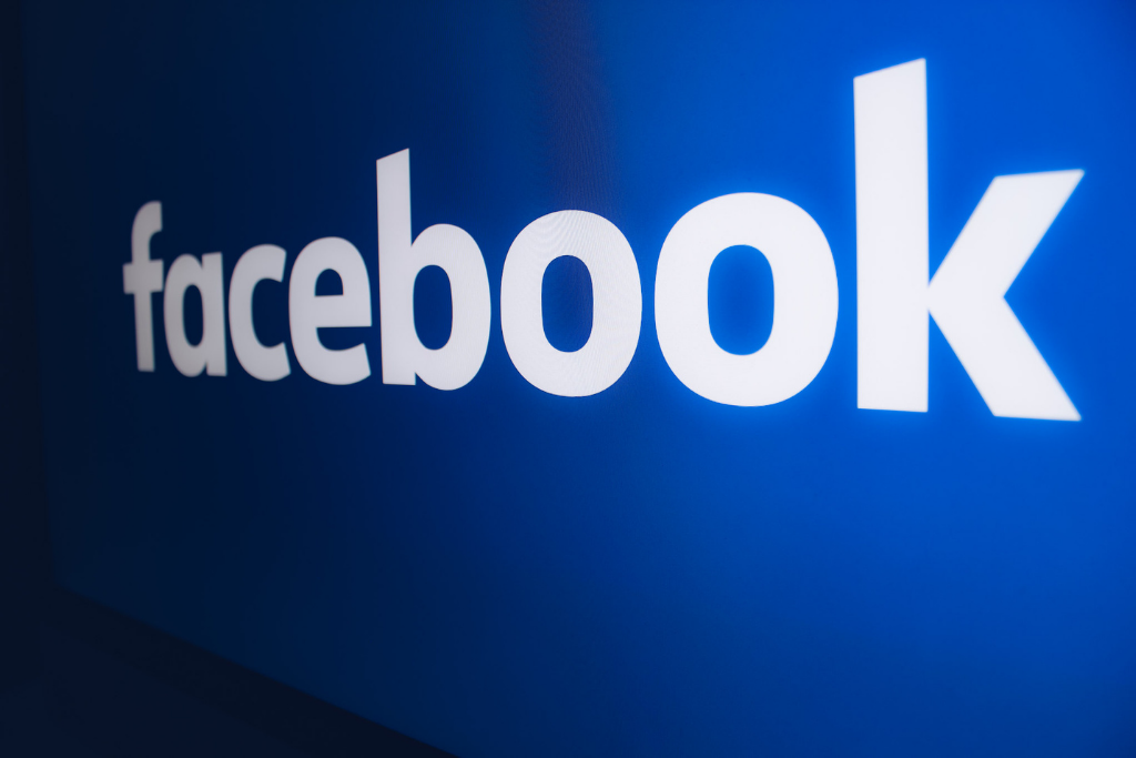 Imagem com o logo do facebook: a palavra "facebook" escrita em fontes brancas e um fundo azul. 